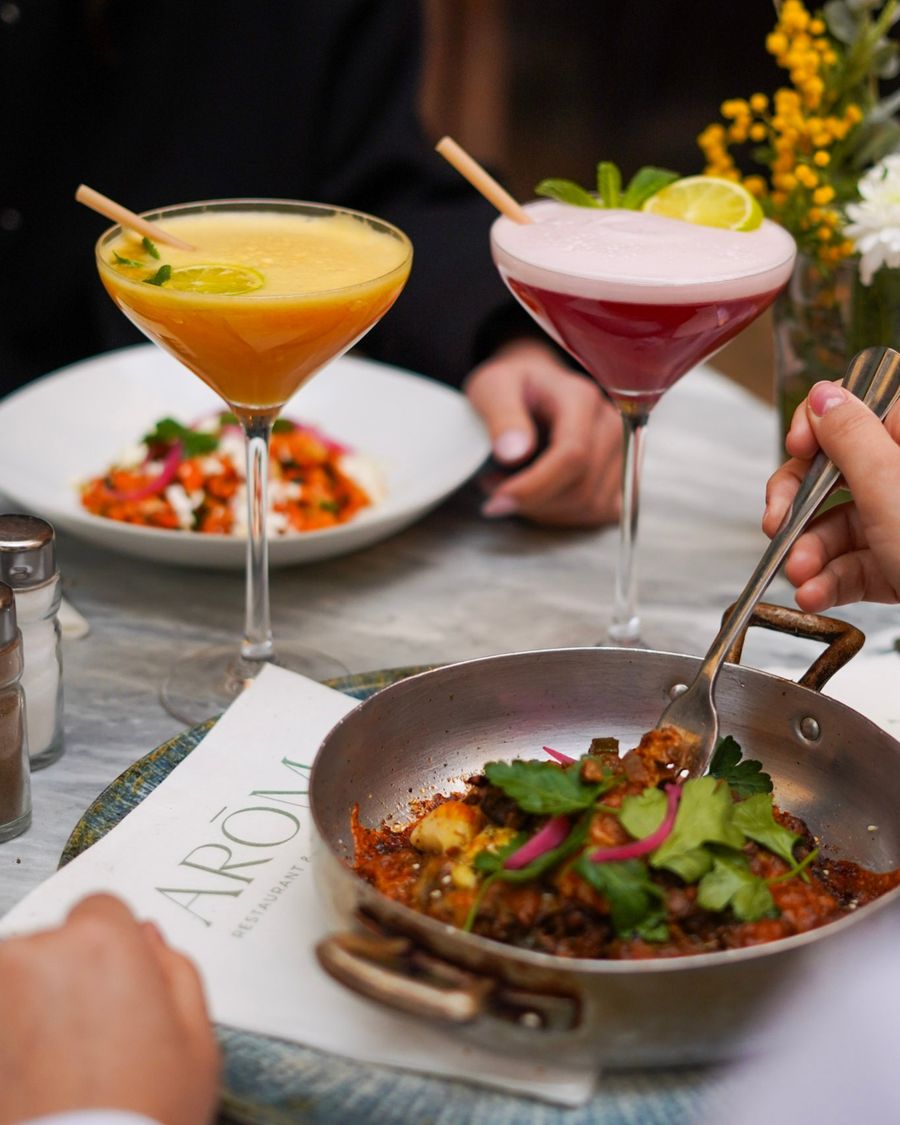 Table partagée chez ARÓM, un plat mijoté servi au cuivre entre deux cocktails, sur un plateau de marbre
