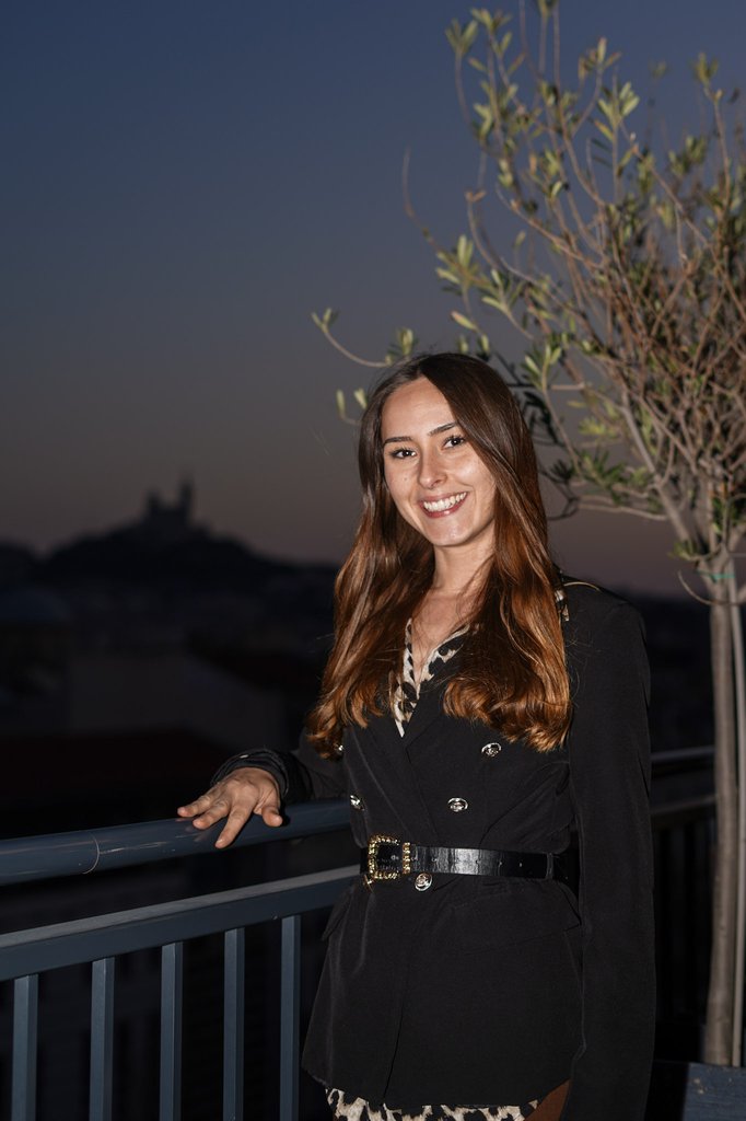 Membre de l'équipe Digiflow souriante sur le rooftop du séminaire, Notre-Dame de la Garde en fond